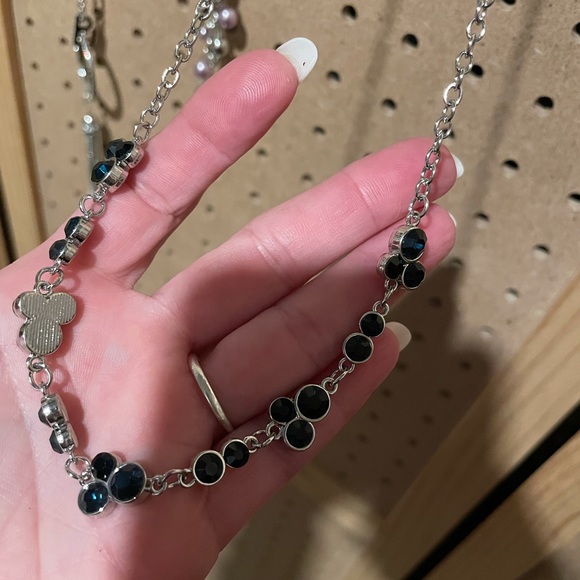 Short silver necklace with Mickey Mouse shape design clusters.